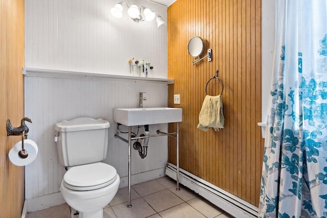 full bathroom with a shower with shower curtain, a sink, tile patterned flooring, a baseboard heating unit, and toilet