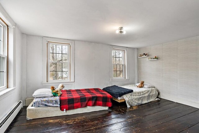 bedroom featuring hardwood / wood-style floors and a baseboard radiator