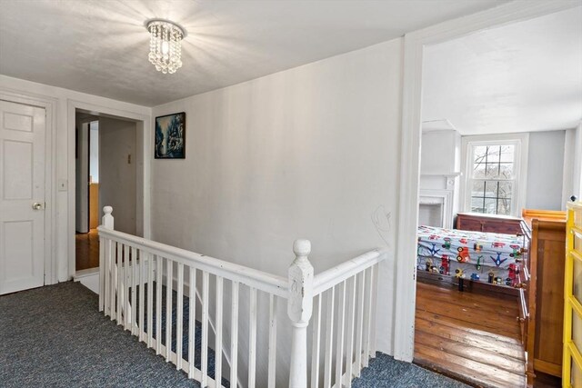 hall featuring an upstairs landing and carpet flooring