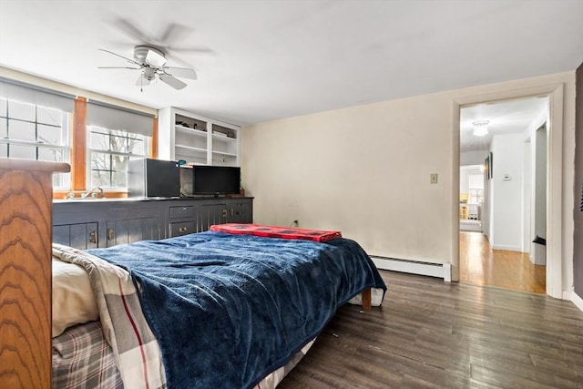 bedroom featuring wood finished floors, baseboard heating, and ceiling fan