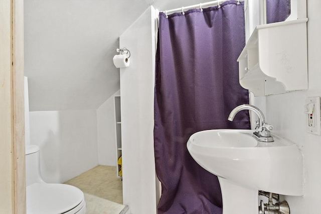 full bathroom featuring a shower with shower curtain, vaulted ceiling, toilet, and a sink