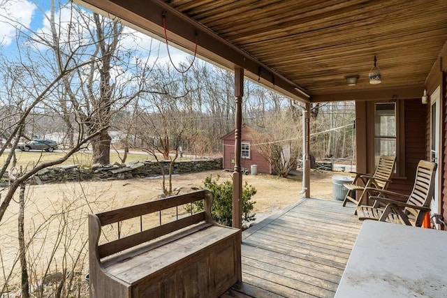 wooden deck with a storage shed and an outdoor structure