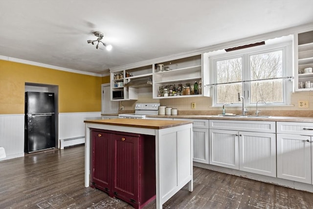 kitchen with butcher block countertops, white electric range, a baseboard heating unit, freestanding refrigerator, and wainscoting