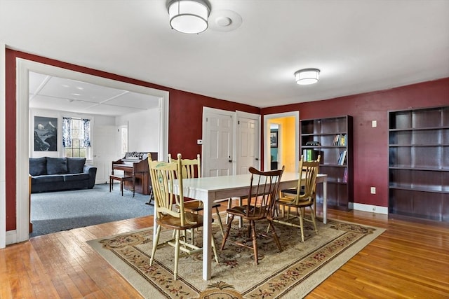 dining space featuring baseboards and hardwood / wood-style flooring