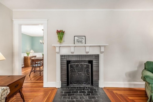 interior details featuring crown molding, an inviting chandelier, parquet floors, a fireplace, and a baseboard heating unit