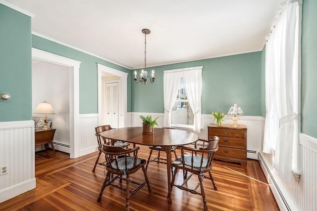 dining room featuring a notable chandelier, crown molding, and baseboard heating