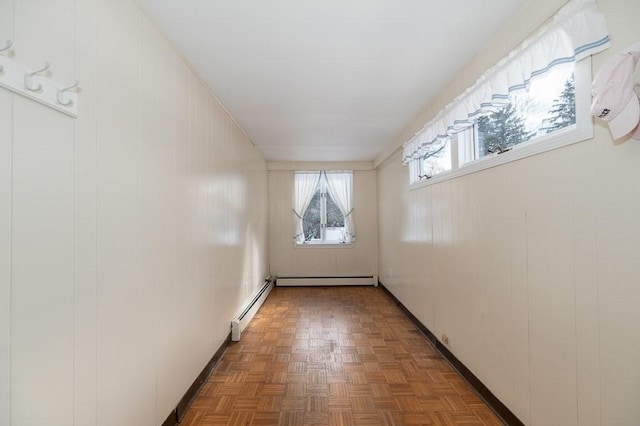 interior space with a baseboard heating unit and dark parquet floors