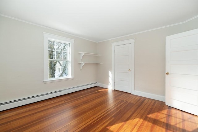 spare room with hardwood / wood-style flooring, ornamental molding, and a baseboard heating unit