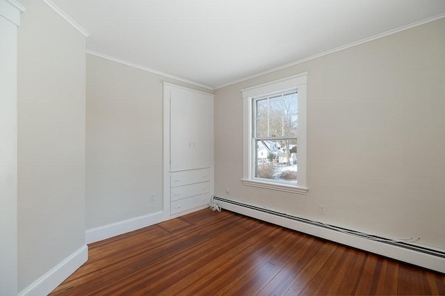 spare room with hardwood / wood-style flooring, crown molding, and baseboard heating