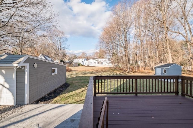 wooden deck with a yard and a storage unit