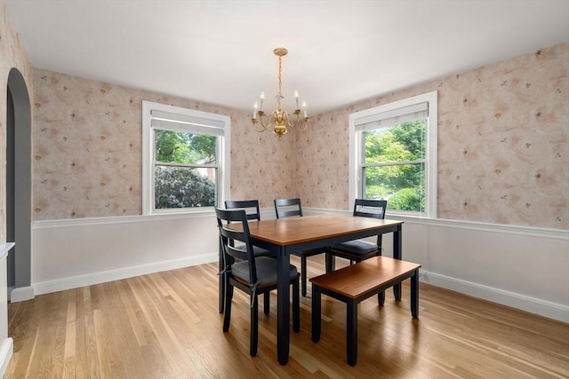 72 Lyall St, Boston, MA 02132 - dining room featuring arched walkways, wood finished floors, healthy amount of natural light, a chandelier, and wallpapered walls