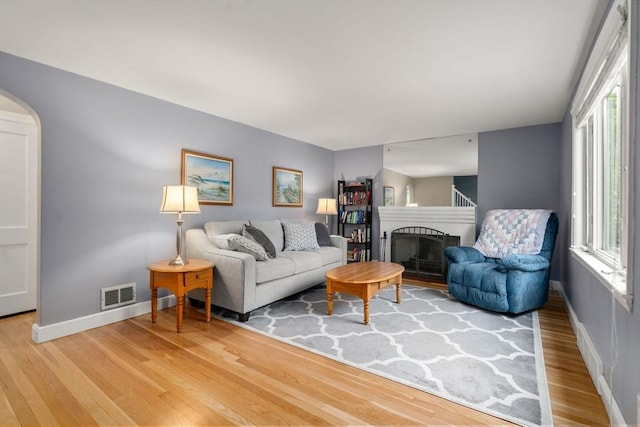 72 Lyall St, Boston, MA 02132 - living area with wood finished floors, arched walkways, and a fireplace