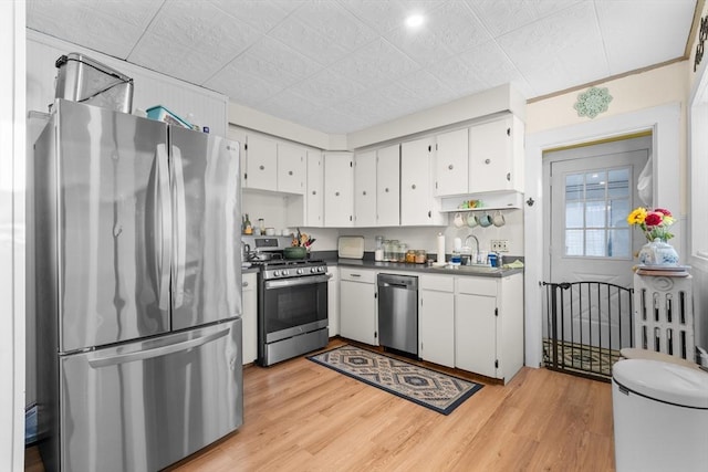 kitchen featuring sink, stainless steel appliances, light wood-type flooring, and white cabinetry