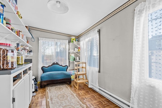 living area with a baseboard heating unit and light parquet flooring