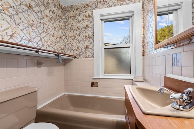 bathroom with a bathtub, vanity, and toilet