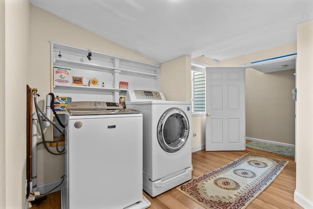 washroom with washer and dryer and light hardwood / wood-style floors