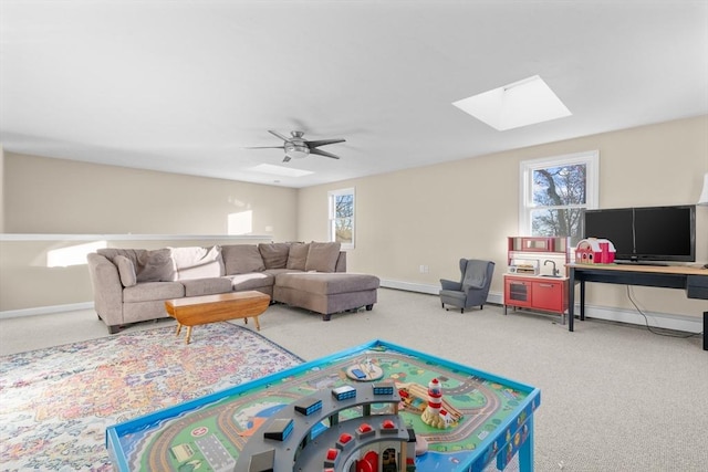 recreation room featuring ceiling fan, a skylight, and carpet floors