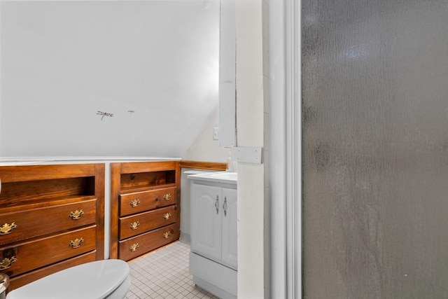 bathroom with lofted ceiling, vanity, and toilet