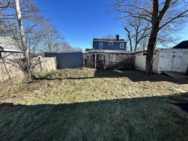 back of property with a lawn, a storage unit, and a sunroom