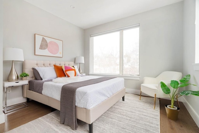 bedroom with baseboards and wood finished floors