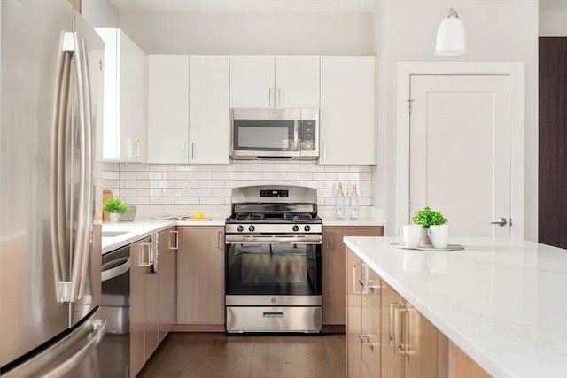 kitchen featuring dark wood-type flooring, white cabinetry, stainless steel appliances, and backsplash