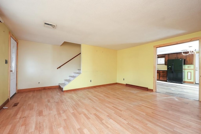 unfurnished living room featuring light hardwood / wood-style floors and a baseboard heating unit