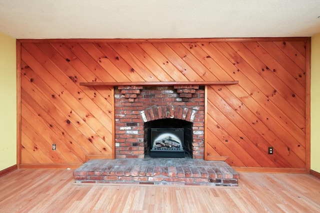 details with a brick fireplace, wooden walls, and hardwood / wood-style flooring