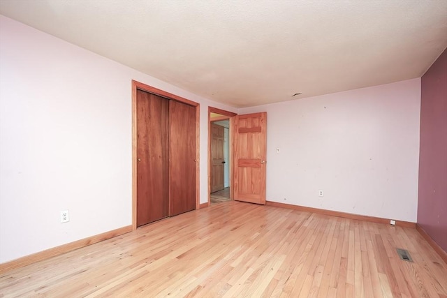 unfurnished bedroom featuring light hardwood / wood-style floors and a closet