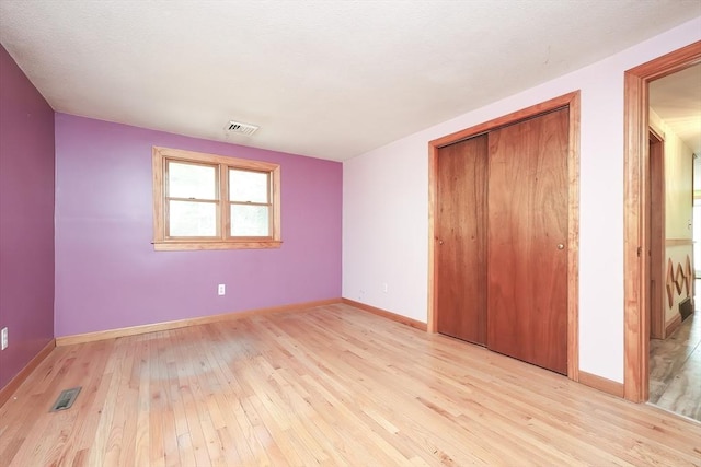 unfurnished bedroom with light hardwood / wood-style flooring and a closet