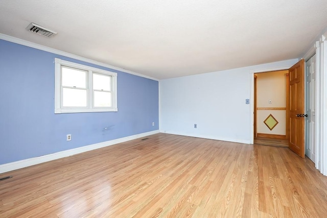 spare room featuring light hardwood / wood-style flooring and crown molding