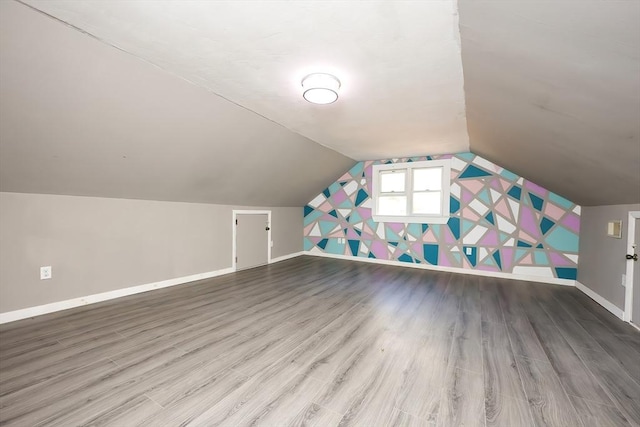 bonus room featuring wood-type flooring and vaulted ceiling