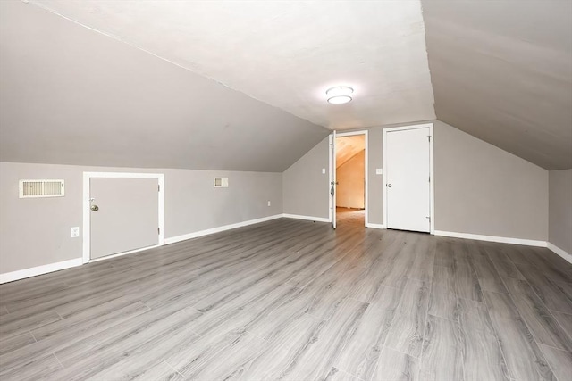 additional living space with lofted ceiling and light wood-type flooring