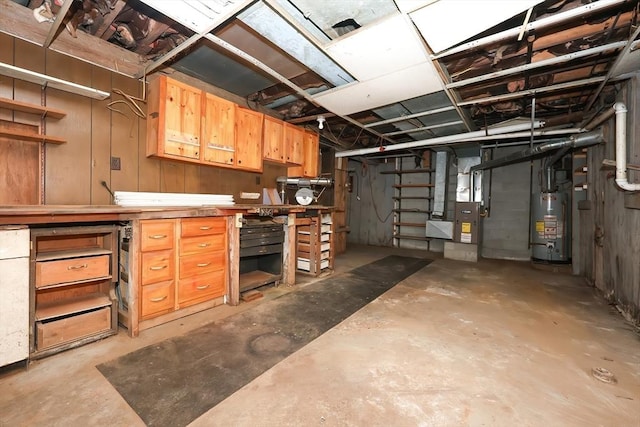 basement featuring a workshop area, heating unit, and water heater