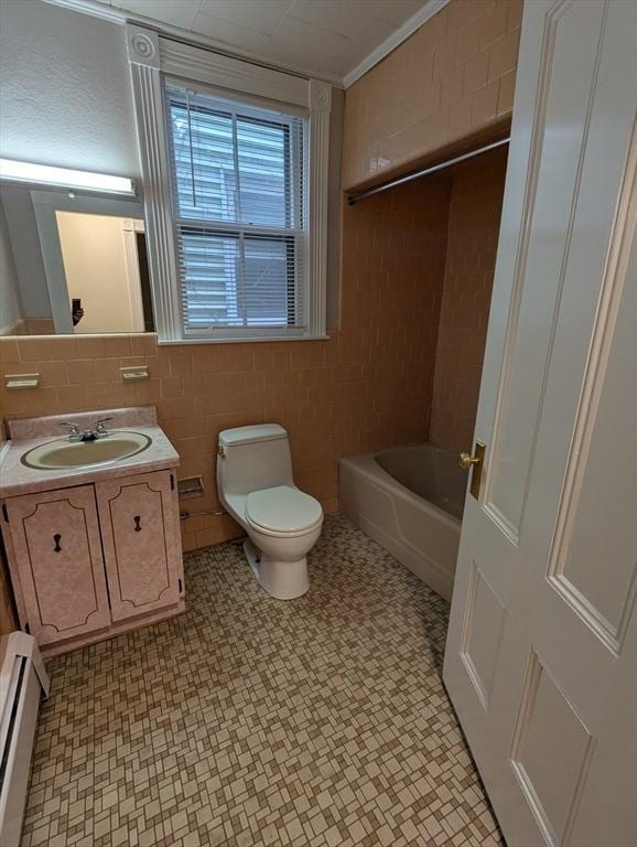 full bath with toilet, baseboard heating, tile walls, and vanity