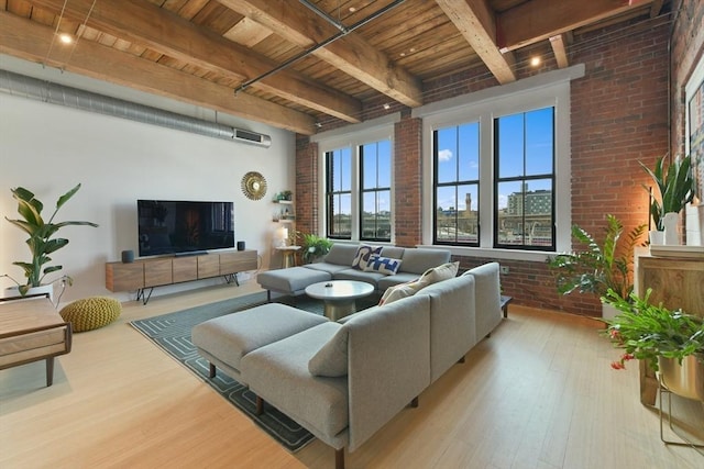 living area with wood ceiling, beamed ceiling, brick wall, and wood finished floors