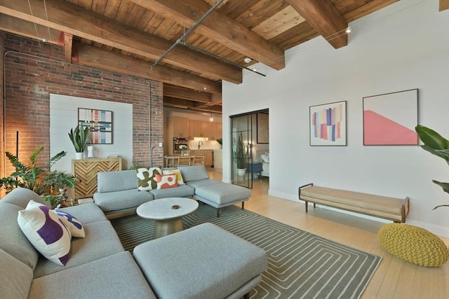 living room featuring brick wall, wooden ceiling, wood finished floors, and beam ceiling