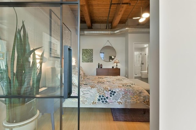 bedroom featuring wood ceiling, wood finished floors, and beamed ceiling