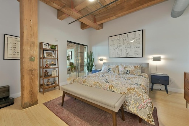 bedroom featuring wooden ceiling, wood finished floors, beam ceiling, and baseboards