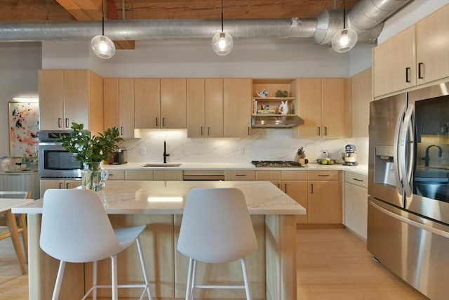 kitchen with backsplash, stainless steel appliances, under cabinet range hood, light brown cabinets, and a sink