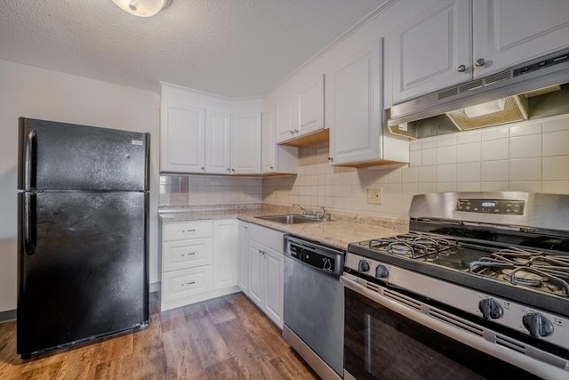 kitchen featuring sink, white cabinetry, light wood-type flooring, appliances with stainless steel finishes, and decorative backsplash