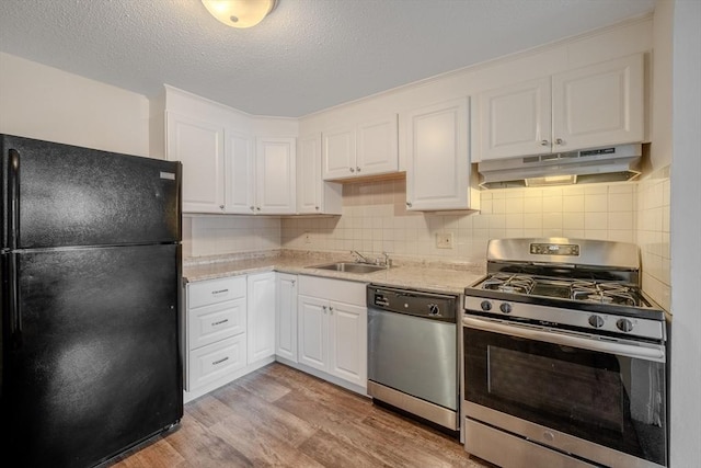 kitchen featuring appliances with stainless steel finishes, sink, white cabinets, and light hardwood / wood-style floors