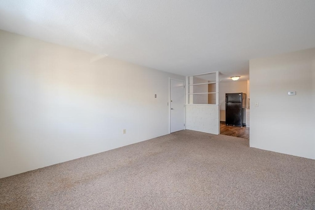 unfurnished room with dark colored carpet