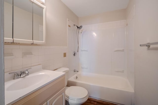 full bathroom with tiled shower / bath combo, vanity, tile walls, and toilet