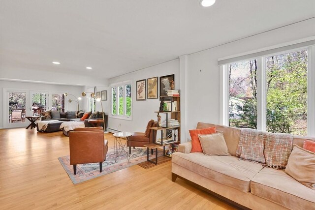 living area with recessed lighting, light wood-style flooring, and baseboard heating