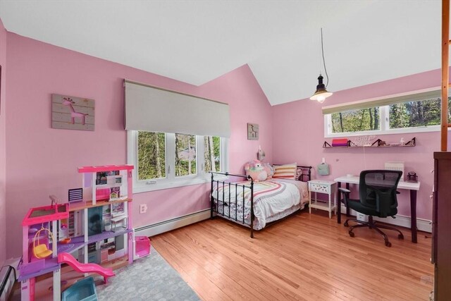 bedroom with multiple windows, a baseboard heating unit, wood finished floors, and lofted ceiling