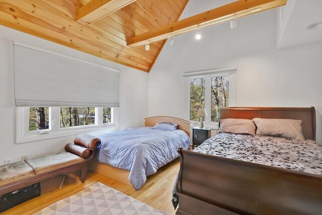 bedroom featuring vaulted ceiling with beams, multiple windows, wood finished floors, and wood ceiling