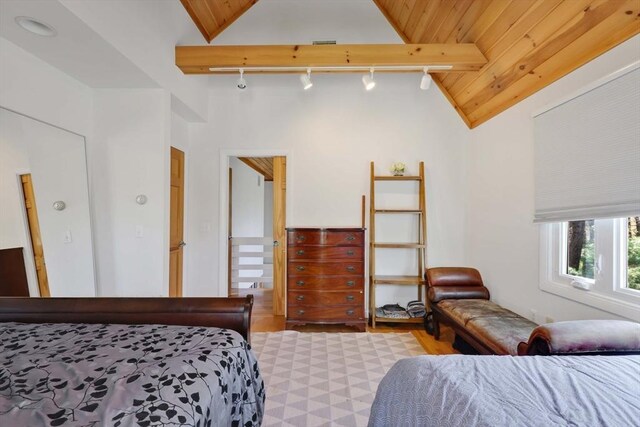 bedroom featuring track lighting, vaulted ceiling with beams, and wood ceiling