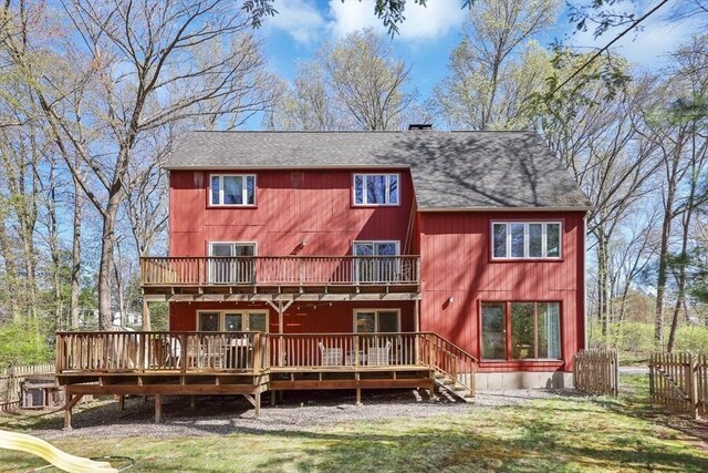 back of property featuring a shingled roof, a wooden deck, a balcony, and fence