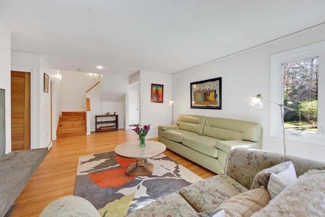 living room with stairway, recessed lighting, and light wood-style flooring