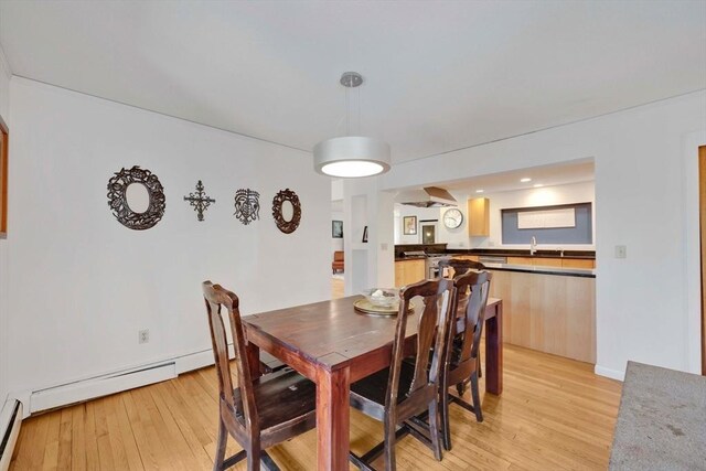dining room with a baseboard heating unit and light wood-style flooring
